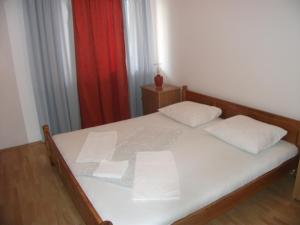 sypialnia z łóżkiem z białą pościelą i czerwoną zasłoną w obiekcie House Lumbarda (876) w mieście Lumbarda