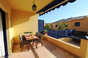 un patio con tavolo e sedie su un balcone di Bahia Meloneras a Meloneras