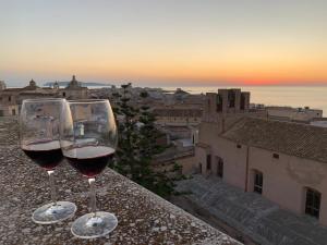 two glasses of wine sitting on top of a ledge at La Terrazza su Trapani - Alloggio Roma in Trapani