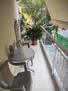 uma varanda com mesa, cadeiras e plantas em Alimos Apartment em Atenas