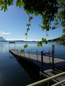 a dock on a lake with mountains in the distance at Serenity Cottage Feriolo in Baveno