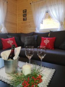 salon z kieliszkami do wina i kanapą w obiekcie GRABSKA OSADA APARTAMENTY - 100m od Suntago Park-domki ogrzewane całoroczne w Mszczonowie