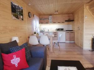 uma sala de estar com um sofá e uma cozinha em GRABSKA OSADA APARTAMENTY - 100m od Suntago Park-domki ogrzewane całoroczne em Mszczonów