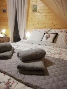 Un dormitorio con una cama grande con almohadas. en GRABSKA OSADA APARTAMENTY - 100m od Suntago Park-domki ogrzewane całoroczne, en Mszczonów