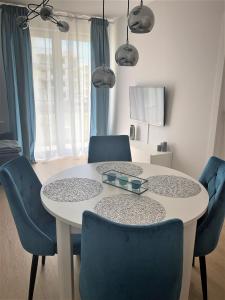 科沃布熱格的住宿－Apartament Azzurro Porta Mare Baltica Kołobrzeg，周围设有一张带蓝色椅子的餐桌