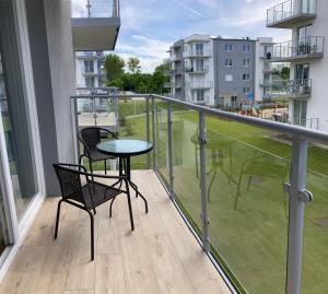 科沃布熱格的住宿－Apartament Azzurro Porta Mare Baltica Kołobrzeg，阳台配有两把椅子和一张桌子