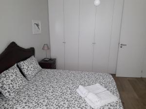 a bedroom with a bed with two towels on it at Garden House Ramalde in Porto