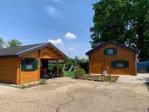 eine Blockhütte mit einer Terrasse und einem Haus in der Unterkunft mySeenland in Senftenberg