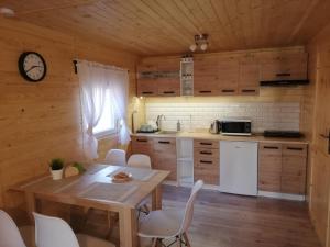 uma cozinha com mesa e cadeiras e um relógio em GRABSKA OSADA APARTAMENTY - 100m od Suntago Park-domki ogrzewane całoroczne em Mszczonów