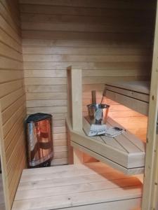 a sauna with a stove and a trash can at Huoneisto Villa Kaitera in Kuusamo
