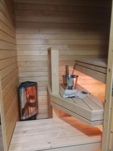 uma sauna com um fogão e uma lata de lixo em Huoneisto Villa Kaitera em Kuusamo