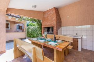 a kitchen with a wooden table and a fireplace at Country Villa (3642) in Loborika