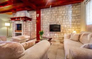 a living room with couches and a stone wall at Country Villa (3642) in Loborika