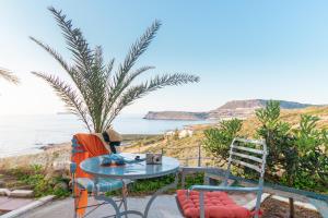 stół i krzesła siedzące obok oceanu w obiekcie Liogerma Resorts w mieście Sitia