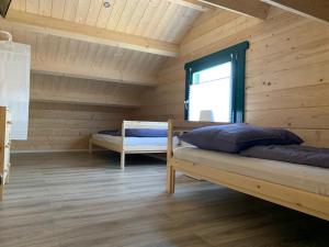 a bedroom with two beds in a wooden cabin at mySeenland in Senftenberg
