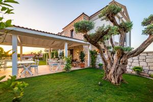 un patio con un albero nel cortile di CEMAL ALAÇATI BUTİK HOTEL ad Alaçatı