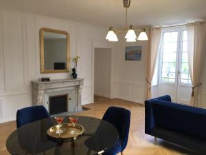 a living room with a table and chairs and a fireplace at La Promenade - Appartement de charme avec vue sur le canal et ses écluses - Centre historique in Redon