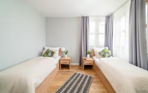 Duas camas num quarto com uma janela em Apartament Karkonoskie Tarasy em Karpacz