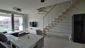 a living room with a couch and a staircase at Isola Blu Luxury Apartment in Lido di Jesolo