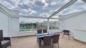 a balcony with a table and chairs and a large window at Isola Blu Luxury Apartment in Lido di Jesolo