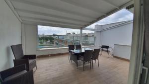 a dining room with a table and chairs and a large window at Isola Blu Luxury Apartment in Lido di Jesolo