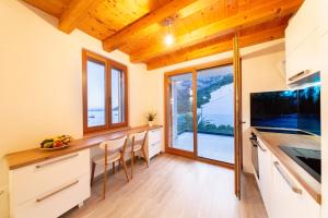 a kitchen with wooden ceilings and a large window at Villa Aida in Komiža