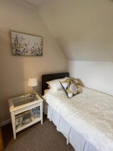 una camera con letto e tavolo con lampada di Fairview Bed and Breakfast ad Airdrie