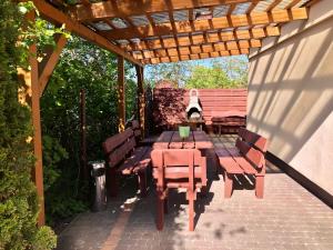 patio con tavolo e sedie sotto un pergolato di Pokoje gościnne ZUZA a Władysławowo