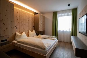 a bedroom with a large bed with a window at Lechthaler Apartments in Resia