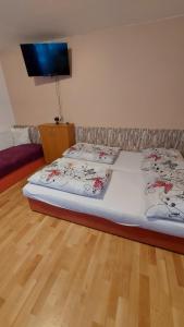 a bedroom with two beds and a flat screen tv at Pension U Štěpánků in Trpišovice