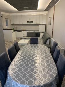 a living room with a large table and a kitchen at Apartman Bojanić in Trebinje +9 photos