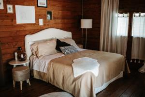1 dormitorio con 1 cama en una habitación con paredes de madera en L'Anfora Country Club en Basciano