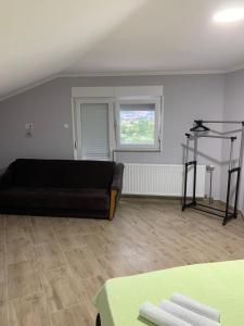 a living room with a black couch and a window at Apartman Bojanić in Trebinje