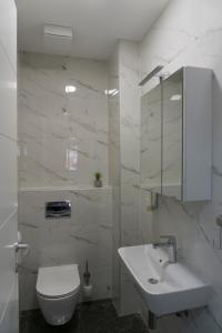 een witte badkamer met een toilet en een wastafel bij APARTMAN AURORA in Trebinje