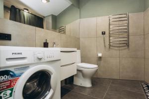 een badkamer met een wasmachine en een toilet bij Apart Lux Loft Panorama in Sumy