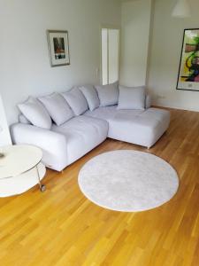 Ruhige zentrale Lage in Bad Honnef في باد هونيف آم راين: غرفة معيشة مع أريكة بيضاء وسجادة بيضاء