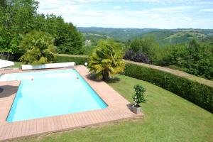 uma piscina no meio de um relvado com árvores em Bienvenue dans notre Gîte em Naves