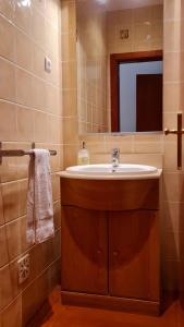 a bathroom with a sink and a mirror at Apartment T3 - Frei Joao - Pleasant and cozy in Tavira