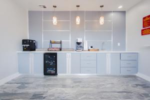 una cocina blanca con armarios y electrodomésticos azules en Palace Inn Beltway 8 & Westview en Houston