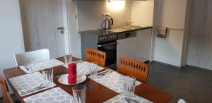 a dining room with a table and chairs and a kitchen at Apartmány Harrachov 288 in Harrachov