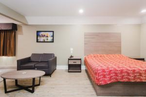 ヒューストンにあるPalace Inn Beltway 8 & Westviewのベッドとソファのあるホテルの部屋