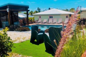 a yard with a pool with chairs and a house at Aigue-marine in Sainte-Anne
