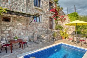 a house with a swimming pool next to a building at Villa Old Olive 2 in Budva