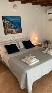 a bedroom with a white bed with towels on it at Giardino dei Baroni house in Marina di Mancaversa
