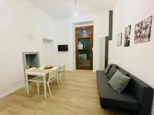 un soggiorno con divano nero e tavolo di Casa Mole a Torino