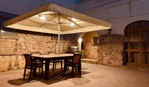 a table with chairs and an umbrella in a room at Mejda Farmhouse in Victoria