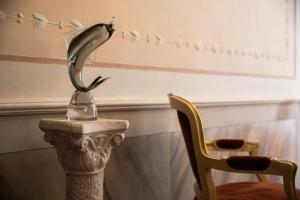 a statue of a bird sitting on a pole next to a chair at Hidden Gem in Venice in Venice