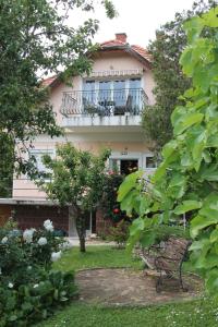 バラトンフレドにあるApartman Villa Magdalenaのバルコニー付きの家、中庭にベンチがあります。