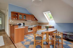 a kitchen with wooden cabinets and a table and chairs at Apartman Villa Magdalena in Balatonfüred