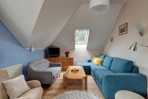 a living room with a blue couch and chairs at Apartman Villa Magdalena in Balatonfüred